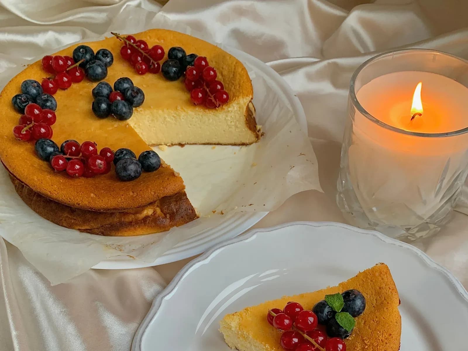 Kuchenstück mit frischen Beeren auf einem weißen Teller